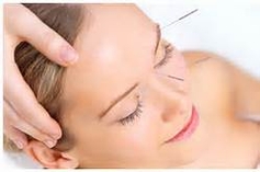 Photo of woman with needles in forehead 